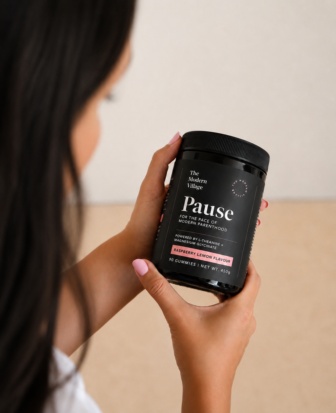 Woman holding a jar of Pause gummies.