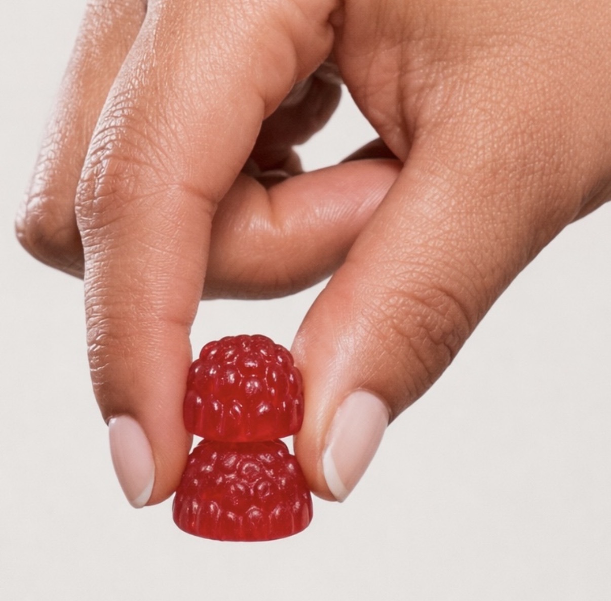 Pause Gummies amber jar on linen with raspberries and lemon